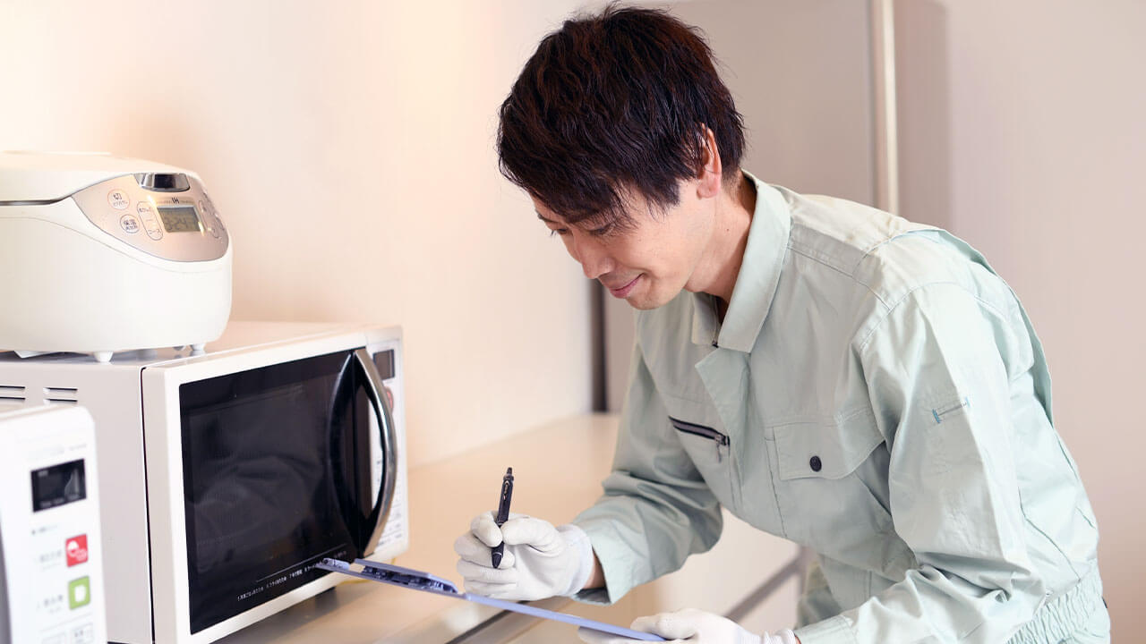 自宅に来て家電を査定している男性